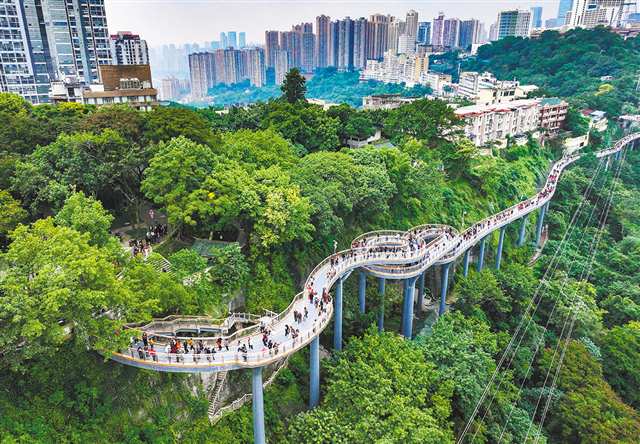 Elevated pedestrian skywalk crossing a green hillside in Chongqing